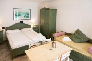 a room with a bed and a table and chairs at Residence Casa Gardola, GTSGroup in Tignale