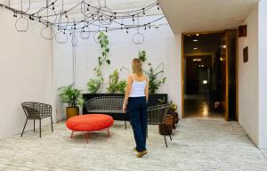 a woman walking in a room with a red chair at Kundera Hotel Boutique in Colima