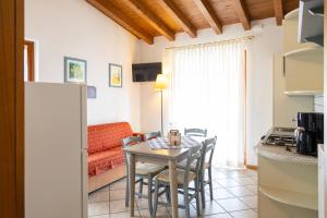 a kitchen and living room with a table and chairs at Residence Casa Gardola, GTSGroup in Tignale