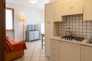 a kitchen with white cabinets and a stove top oven at Residence Casa Gardola, GTSGroup in Tignale +21 photos