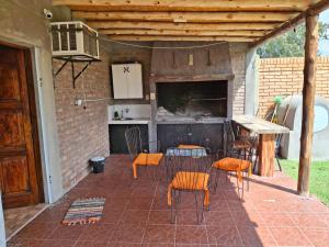 a patio with chairs and a table and a kitchen at Osvaldo Day Cabin with Pool in Albardón