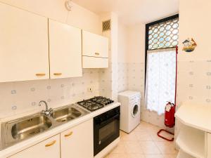 a kitchen with a sink and a stove at Appartamento Eunoia I TerraceParking&AC in Lignano Sabbiadoro