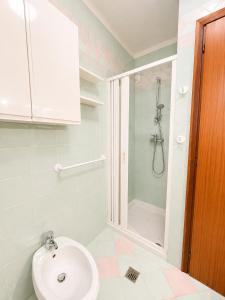 a bathroom with a sink and a shower at Appartamento Eunoia I TerraceParking&AC in Lignano Sabbiadoro