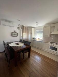 a kitchen with a wooden table and a dining room at My place Čiovo holiday house in Žedno