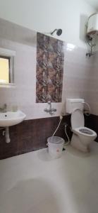 a bathroom with a toilet and a sink at Carmel Stay in Madurai