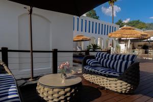 a patio with two chairs and a table and umbrellas at 18 On OniX - World Class in Four Ways