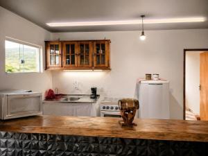 a kitchen with a counter top and a refrigerator at Morada Iluminada Aconchego com Ar condicionado e Lareira in Miguel Pereira