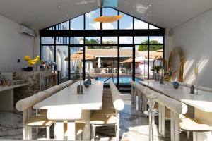 a restaurant with white tables and chairs and a pool at 18 On OniX - World Class in Four Ways