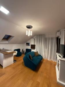 a living room with a blue couch and a television at Cozy Corner Apartments in Bistriţa