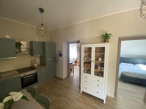 a room with a kitchen and a bedroom with a bed at Domu de Ziu Peppino in Sìnnai