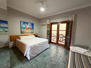 a bedroom with a large bed and a balcony at Ilha Flat Hotel 4201 in Ilhabela +16 photos
