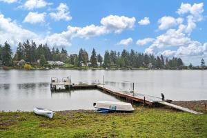 a dock with two boats on the shore of a lake at Seatac Lake Cottage A2 in SeaTac