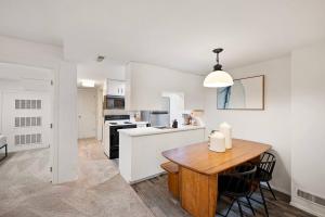 a white kitchen with a wooden table and a dining room at Seatac Lake Cottage A2 in SeaTac