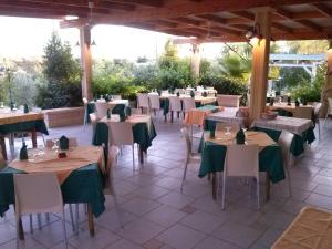 a restaurant with tables and chairs with green napkins at B&B Cèsar in Castrignano del Capo