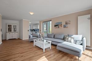a living room with a couch and a table at Dünenhus Appartement Dünenhus in Böhl