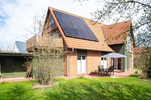 a house with solar panels on the roof at Dünenhus Appartement Dünenhus in Böhl