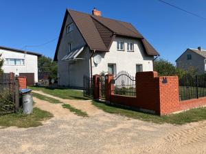 a black and white house with a red brick fence at Don Kichot in Grajewo