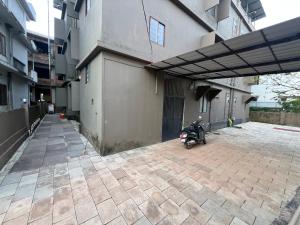 a motorcycle parked next to a building at S S Apartment in Kannur +2 photos