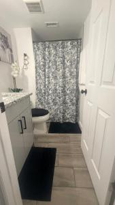 a bathroom with a toilet and a shower curtain at DC lodging LLC in Tampa +4 photos