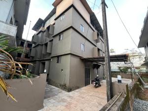 a building with a motorcycle parked in front of it at S S Apartment in Kannur