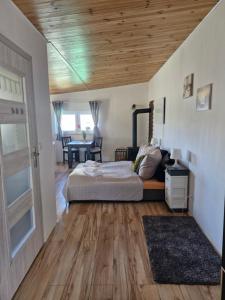 a bedroom with a bed and a wooden ceiling at Chatki przy Marinie in Wapnica