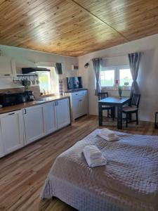 a bedroom with a bed and a kitchen with a table at Chatki przy Marinie in Wapnica