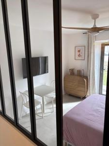 a bedroom with a bed and a table and a chair at Chambre d'hôtes Camélia in Saint-Lyphard