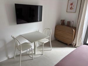 a living room with a table and chairs and a tv at Chambre d'hôtes Camélia in Saint-Lyphard +10 photos