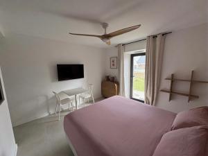 a bedroom with a bed and a table and a window at Chambre d'hôtes Camélia in Saint-Lyphard