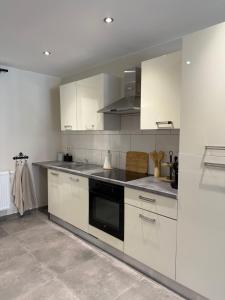 a kitchen with white cabinets and a black oven at La Parenthèse des Charmes in Andenne