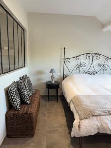 a bedroom with a bed and a chair and a table at La Parenthèse des Charmes in Andenne