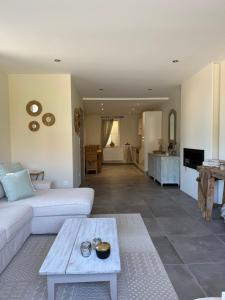 a living room with a white couch and a table at La Parenthèse des Charmes in Andenne