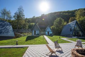 a view of a house with two chairs on a patio at Klek 77 Luxury Chalets near Jahorina in Paočići