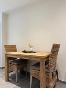 a wooden table with wicker chairs and a dining room at La Parenthèse des Charmes in Andenne +14 photos