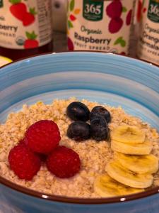 a bowl of oatmeal with strawberries and blueberries and bananas at Chelsea Rooms NYC in New York