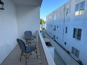 a balcony with two chairs and a table on a building at Surfer's Bungalow in San Diego