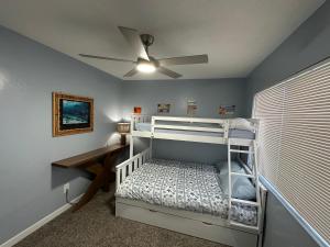 a bedroom with a bunk bed and a ceiling fan at Surfer's Bungalow in San Diego