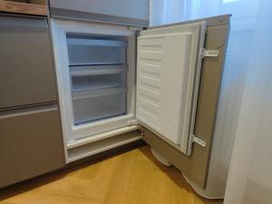 a refrigerator with its door open in a kitchen at Base Camp - Apartmán Klínovec in Kovářská +22 photos