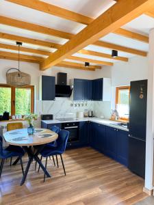 a kitchen with blue cabinets and a table and chairs at Nadbużańska Ostoja in Kamieńczyk