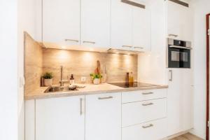 a kitchen with white cabinets and a sink at MiraBlau Braunlage in Braunlage