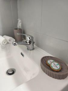 a bathroom sink with a plate of food on it at Lounetta Apartments 2 in Missolonghi +17 photos