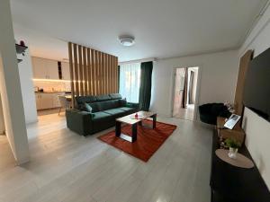 a living room with a green couch and a table at IDDA Concept 1 in Târgu-Mureş