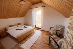 a bedroom with a bed and a large window at Slnečný dvor Bukovinka in Dravce