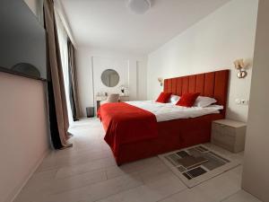 a bedroom with a large red bed with red pillows at IDDA Concept 1 in Târgu-Mureş