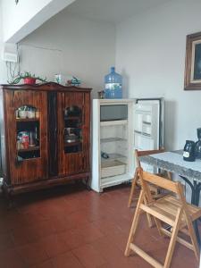 a kitchen with an old wooden cabinet and a refrigerator at Refugio das Laranjeiras Hospedagem in Piraí