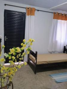 a bedroom with a bed and a window at Refugio das Laranjeiras Hospedagem in Piraí