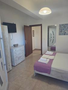 a bedroom with a bed and a dresser with towels at Anemoni apartment Asprovalta in Asprovalta