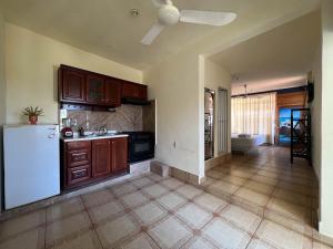 a kitchen with wooden cabinets and a white refrigerator at Casa Piedra Parada in Brisas de Zicatela