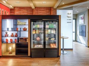 a store with a refrigerator with food in it at ibis Winterthur City in Winterthur