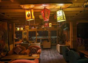 a living room with couches and chairs and lights at Casa Nova in Manāli